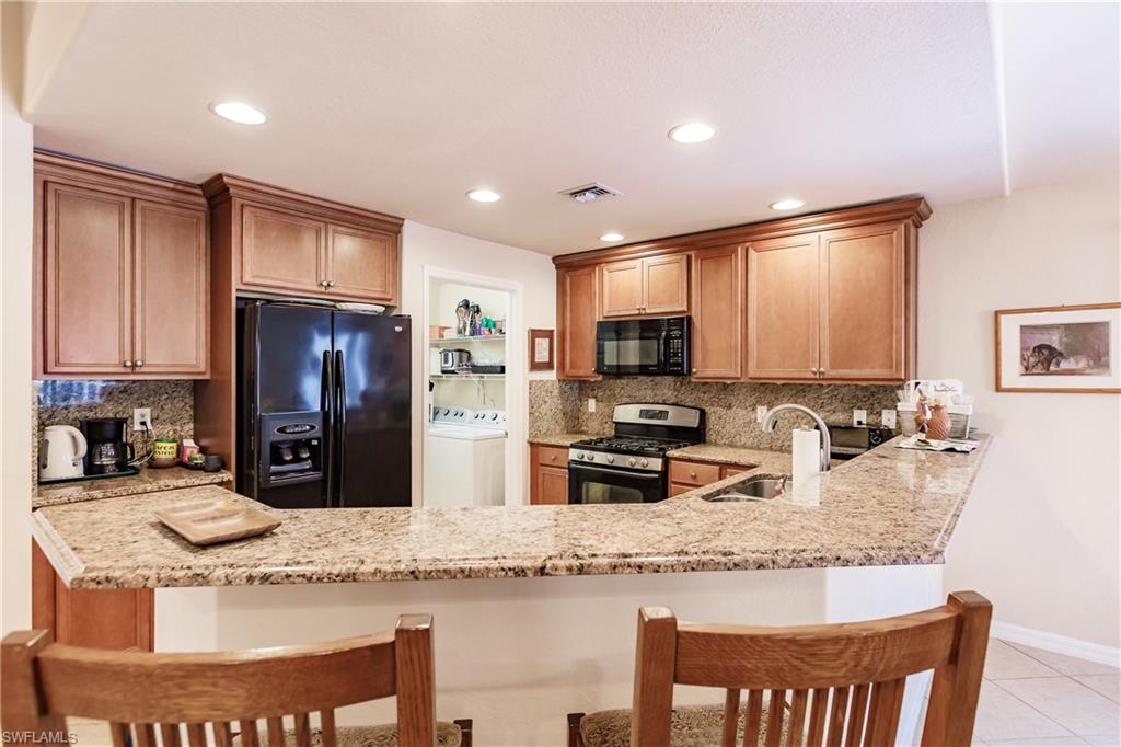 19628 Villa Rosa Loop Estero, FL 33967 - Photo 6 of 25 a kitchen with stainless steel appliances granite countertop a sink refrigerator and microwave