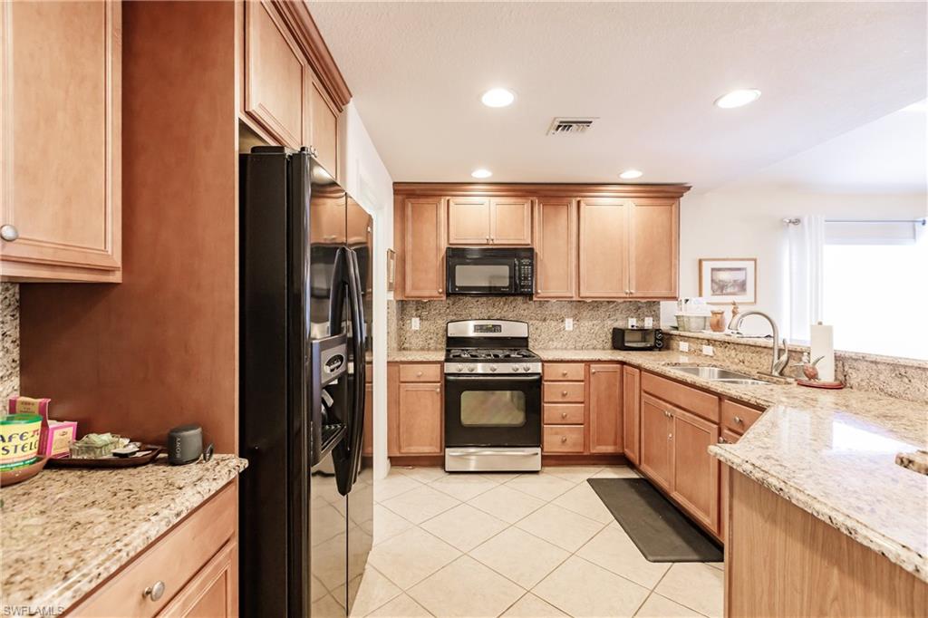 19628 Villa Rosa Loop Estero, FL 33967 - Photo 7 of 25 a kitchen with granite countertop a sink stove and refrigerator