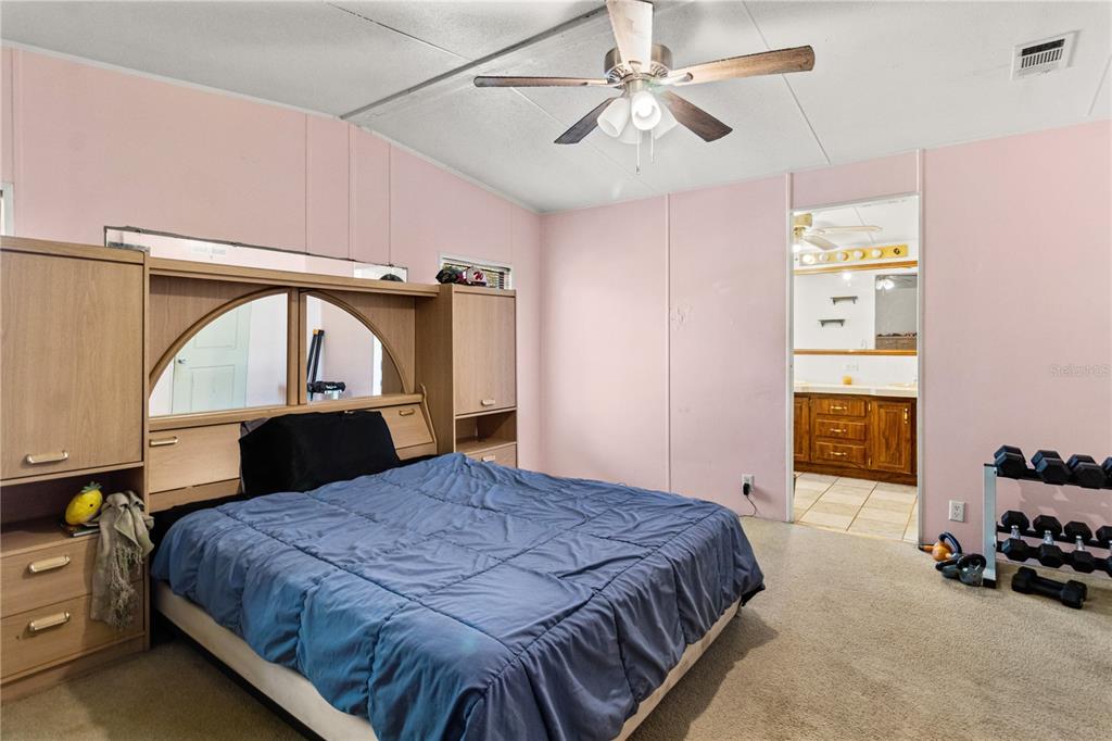 14930 Southeast 2 Lane Williston, FL 32696 - Photo 14 of 20 a bedroom with a bed a dresser and book shelfs