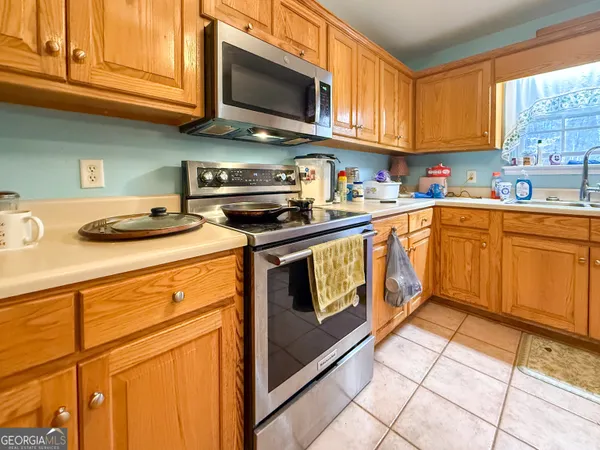 a kitchen with stainless steel appliances granite countertop a stove a sink and a microwave