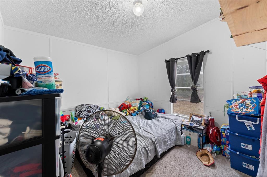 17558 Caufield Road Spring Hill, FL 34610 - Photo 11 of 20 a bedroom with a bed and a window