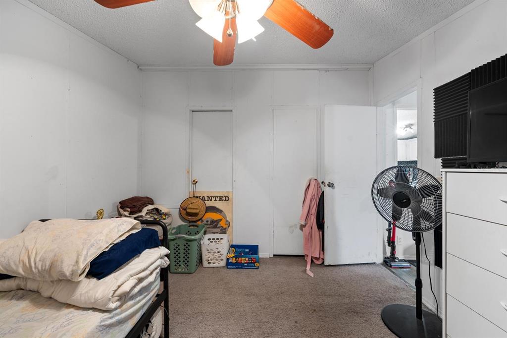 17558 Caufield Road Spring Hill, FL 34610 - Photo 13 of 20 a bedroom with bed and a chandelier