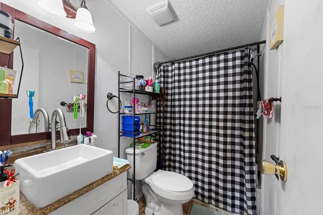 a bathroom with a sink toilet vanity and shower