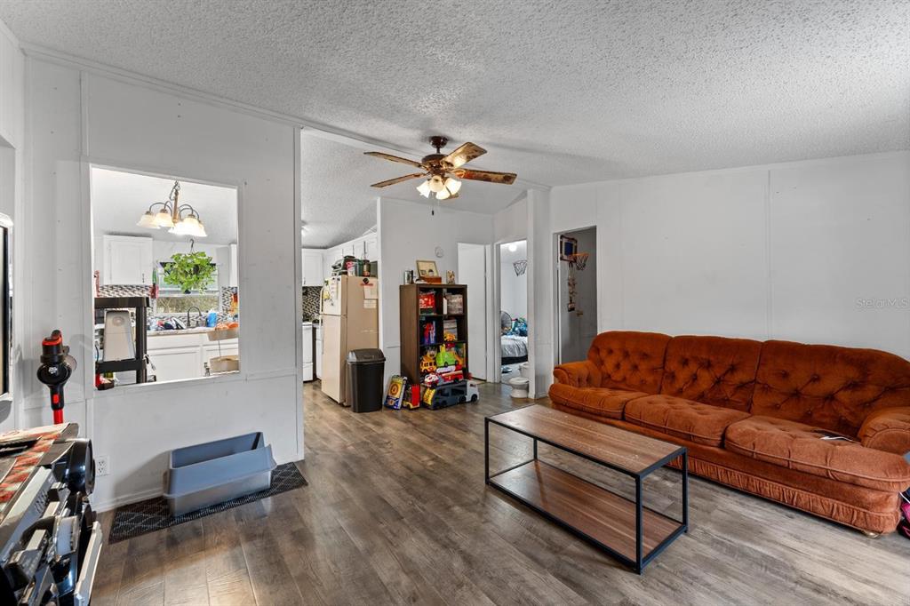 17558 Caufield Road Spring Hill, FL 34610 - Photo 3 of 20 a living room with furniture ceiling fan and a wooden floor