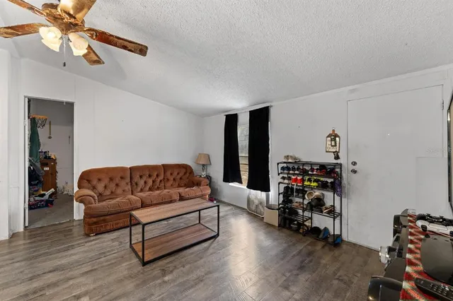 a living room with furniture a flat screen tv and a dresser with wooden floor
