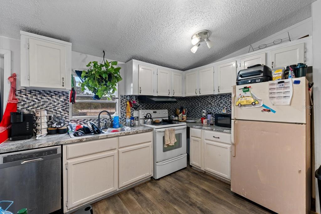 17558 Caufield Road Spring Hill, FL 34610 - Photo 7 of 20 a kitchen with a white cabinets and white appliances