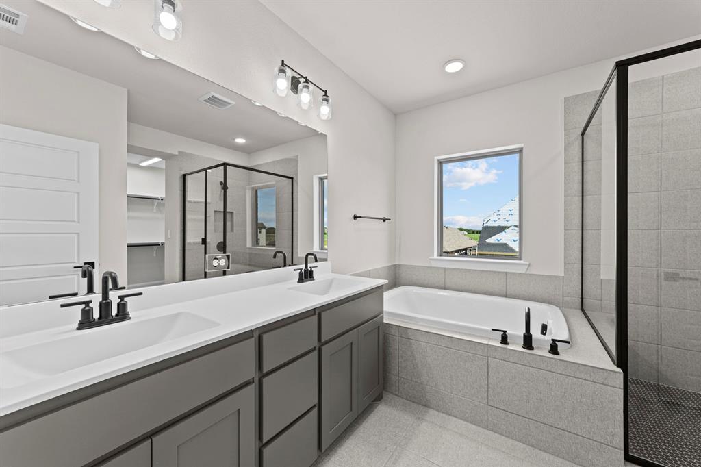 2044 Cuellar Way Van Alstyne, TX 75495 - Photo 12 of 30 a bathroom with a bathtub a double vanity sink and mirror