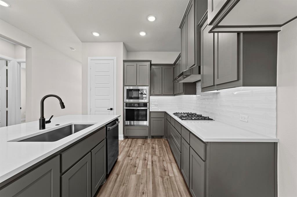 2044 Cuellar Way Van Alstyne, TX 75495 - Photo 21 of 30 a kitchen with stainless steel appliances granite countertop a sink stove and refrigerator