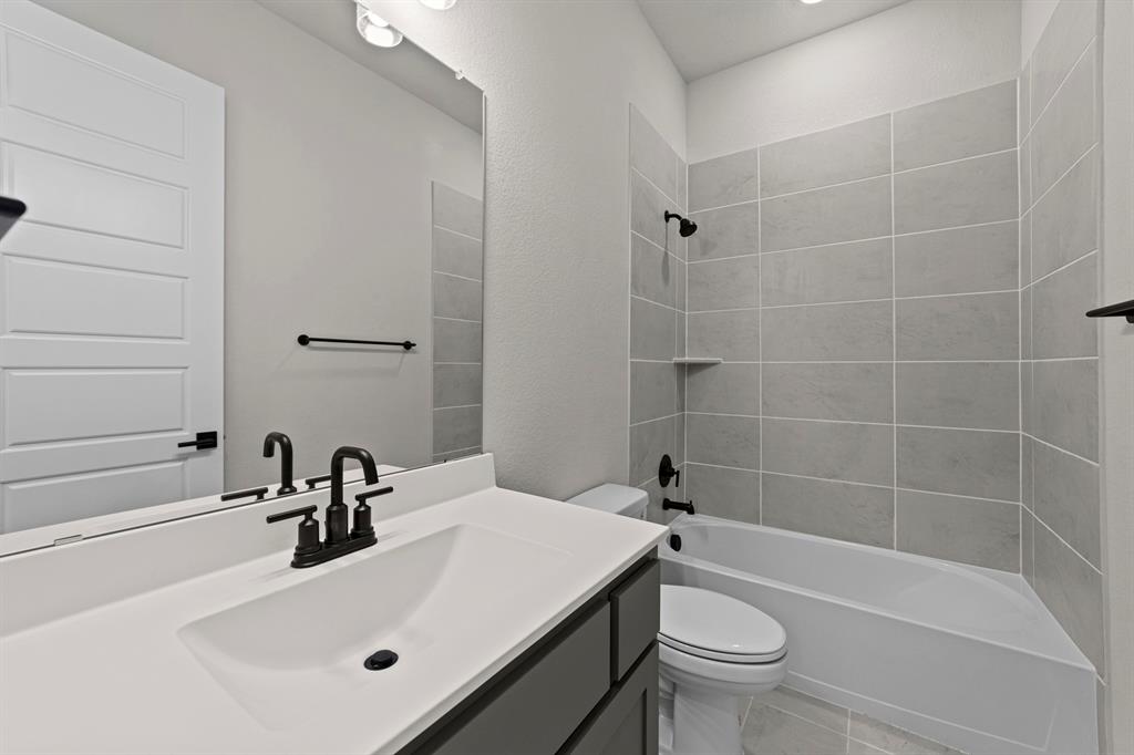 2044 Cuellar Way Van Alstyne, TX 75495 - Photo 25 of 30 a bathroom with a sink a toilet and a bathtub