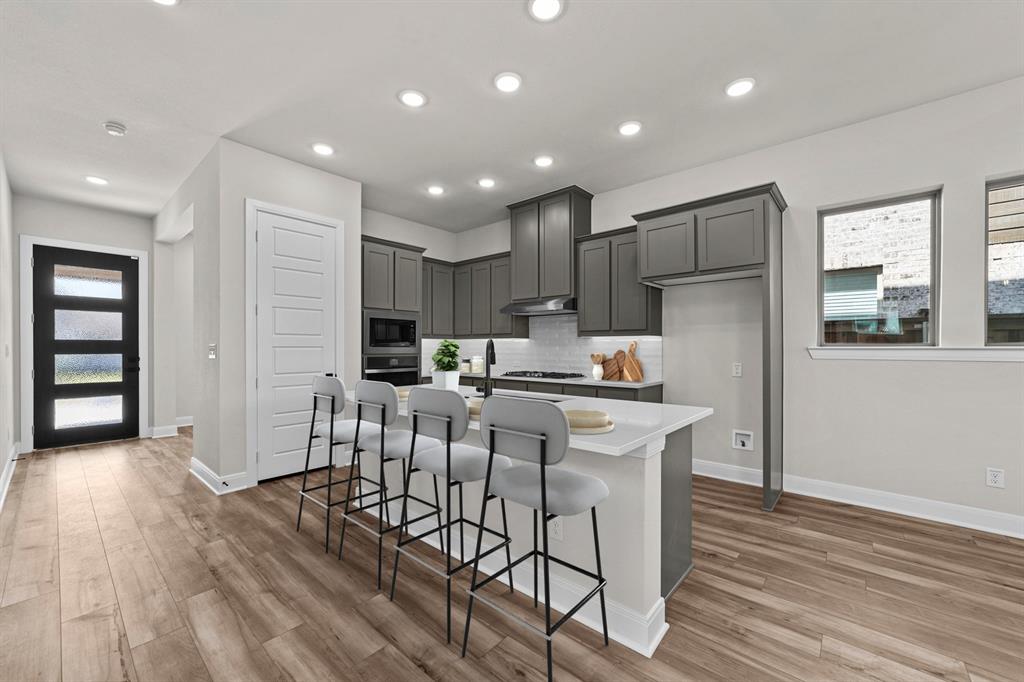 2044 Cuellar Way Van Alstyne, TX 75495 - Photo 7 of 30 a kitchen with stainless steel appliances kitchen island granite countertop a refrigerator and a stove top oven