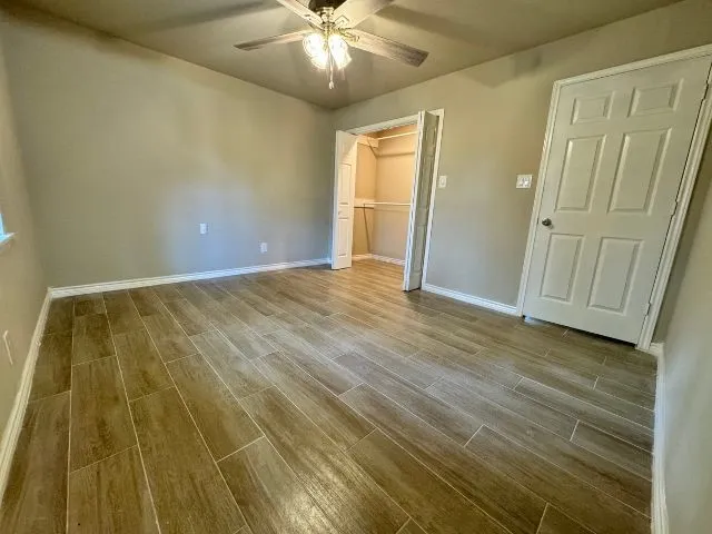 a view of empty room with window and ceiling fan