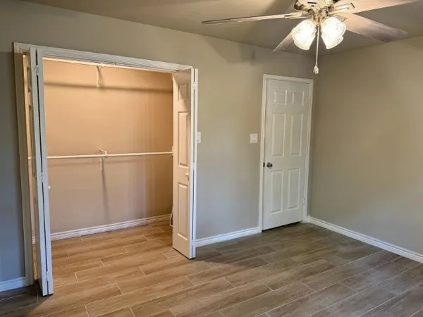 an empty room with windows and fan