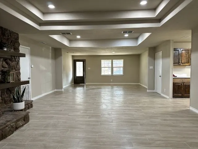 a view of empty room with wooden floor and fireplace