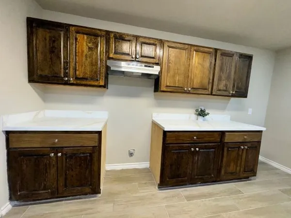 a kitchen with wooden cabinets and a stove top oven