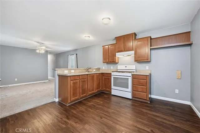 a kitchen with wooden floors and white appliances