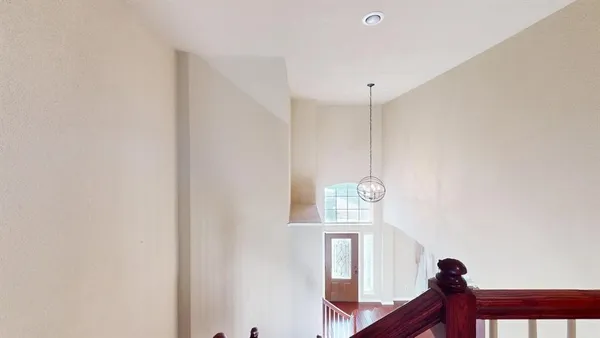 a view of a hallway with windows and chandelier fan