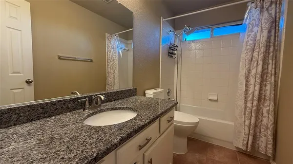 a spacious bathroom with a granite countertop sink and a mirror