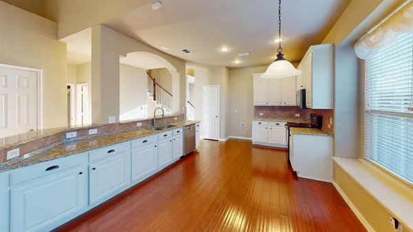 a large kitchen with cabinets a sink and appliances