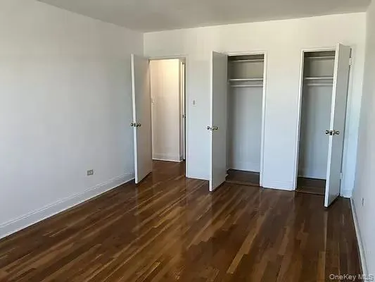 an empty room with wooden floor and closet