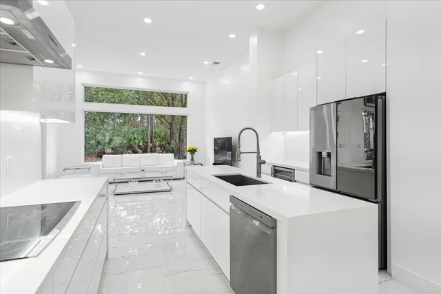 a kitchen with kitchen island white cabinets and stainless steel appliances