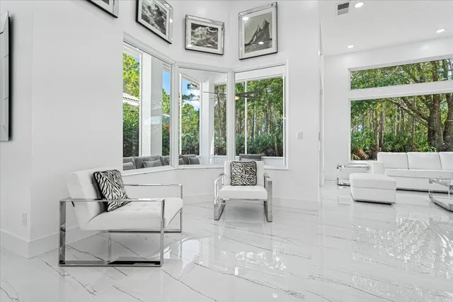 a living room with furniture a flat screen tv and a floor to ceiling window