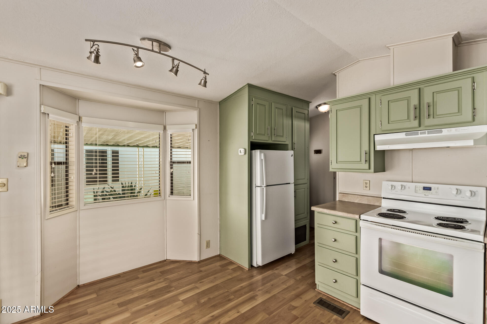 111 South Greenfield Road, Unit 647 Mesa, AZ 85206 - Photo 11 of 29 a kitchen with a refrigerator stove and white cabinets