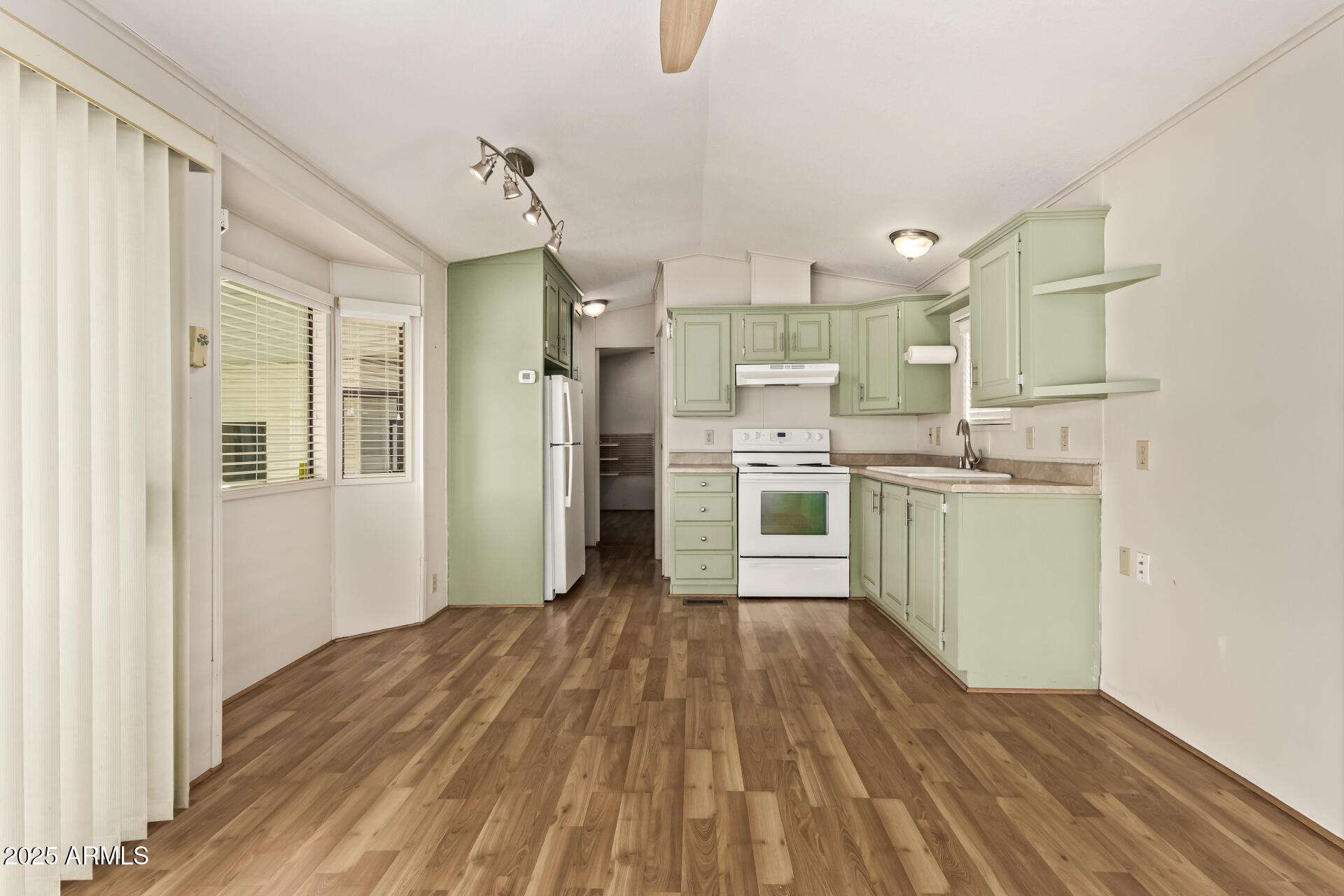 111 South Greenfield Road, Unit 647 Mesa, AZ 85206 - Photo 8 of 29 a kitchen with stainless steel appliances kitchen island wooden floors and white cabinets