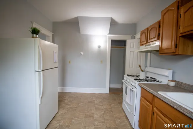 a kitchen with stainless steel appliances granite countertop a refrigerator a stove and a sink