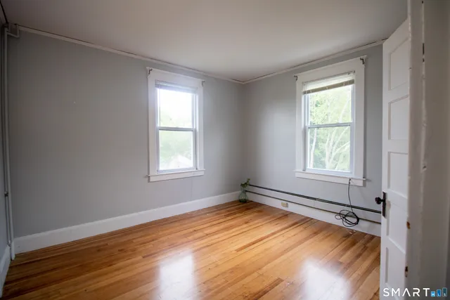 a view of a room with wooden floor and windows
