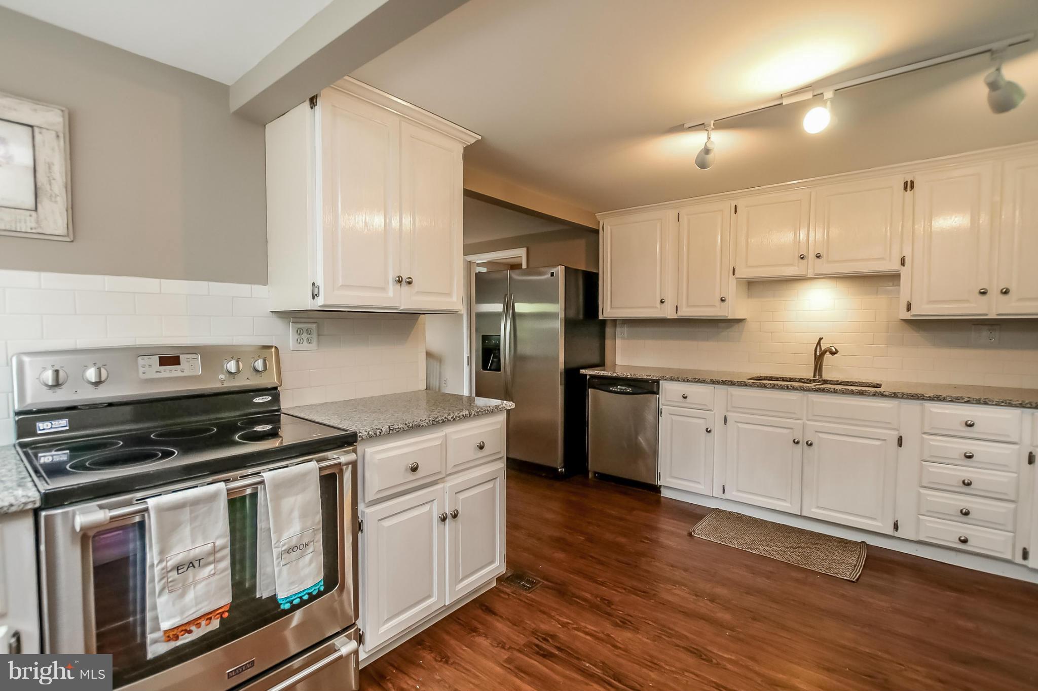 2429 Stanwick Road Phoenix, MD 21131 - Photo 13 of 30 a kitchen with stainless steel appliances white cabinets and a stove top oven