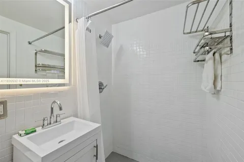 a bathroom with a sink a mirror and shower