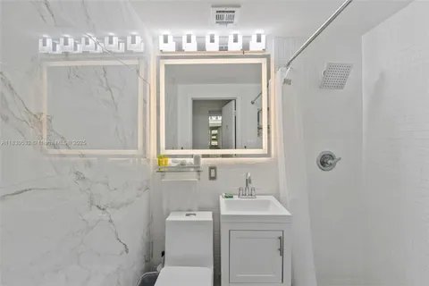 a bathroom with a sink mirror and toilet