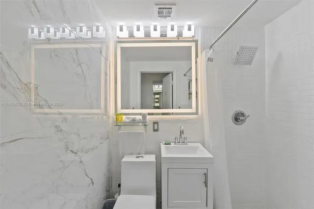 a bathroom with a sink mirror and toilet