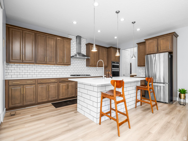877 South Yarrow Drive Mapleton, UT 84664 - Photo 6 of 46 Modern kitchen featuring wood-finish cabinetry, stainless steel appliances, a subway tile backsplash, recessed lighting, and a kitchen island with pendant lighting