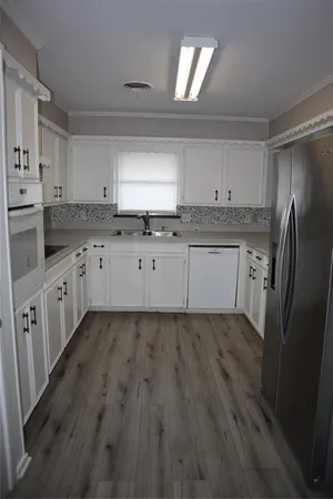 a kitchen with a refrigerator sink and cabinets