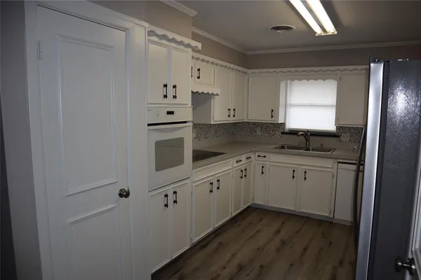 a kitchen with granite countertop white cabinets and black appliances