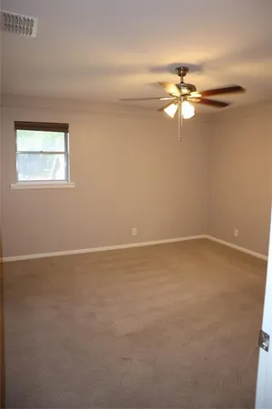 an empty room with a window and a fan