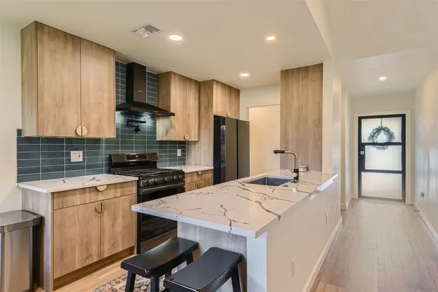 a kitchen with a stove a refrigerator and a stove top oven