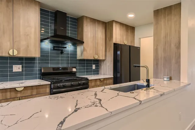 a kitchen with granite countertop wooden cabinets and a refrigerator