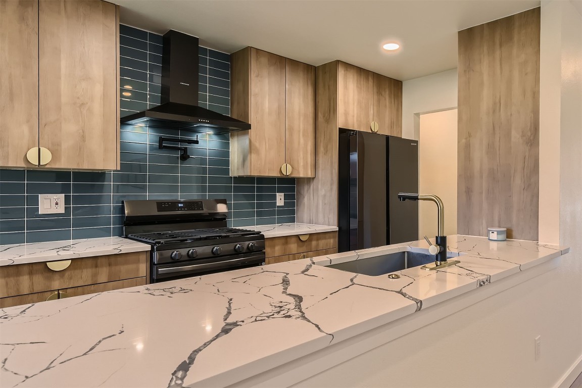 1112 Milford Way Austin, TX 78745 - Photo 10 of 25 a kitchen with granite countertop wooden cabinets and a refrigerator