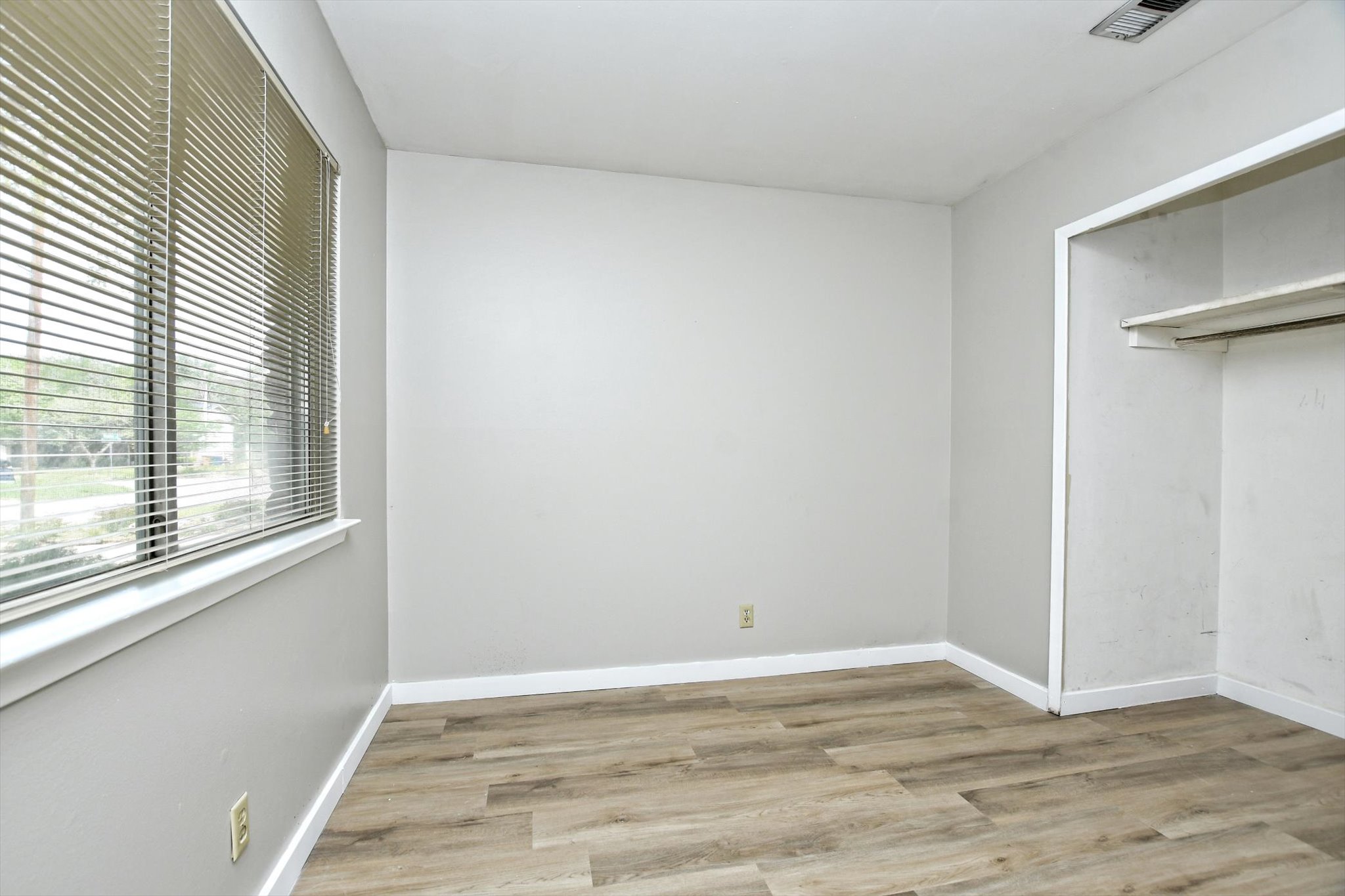7509 Daugherty Street Austin, TX 78757 - Photo 20 of 24 a view of an empty room with wooden floor and a window