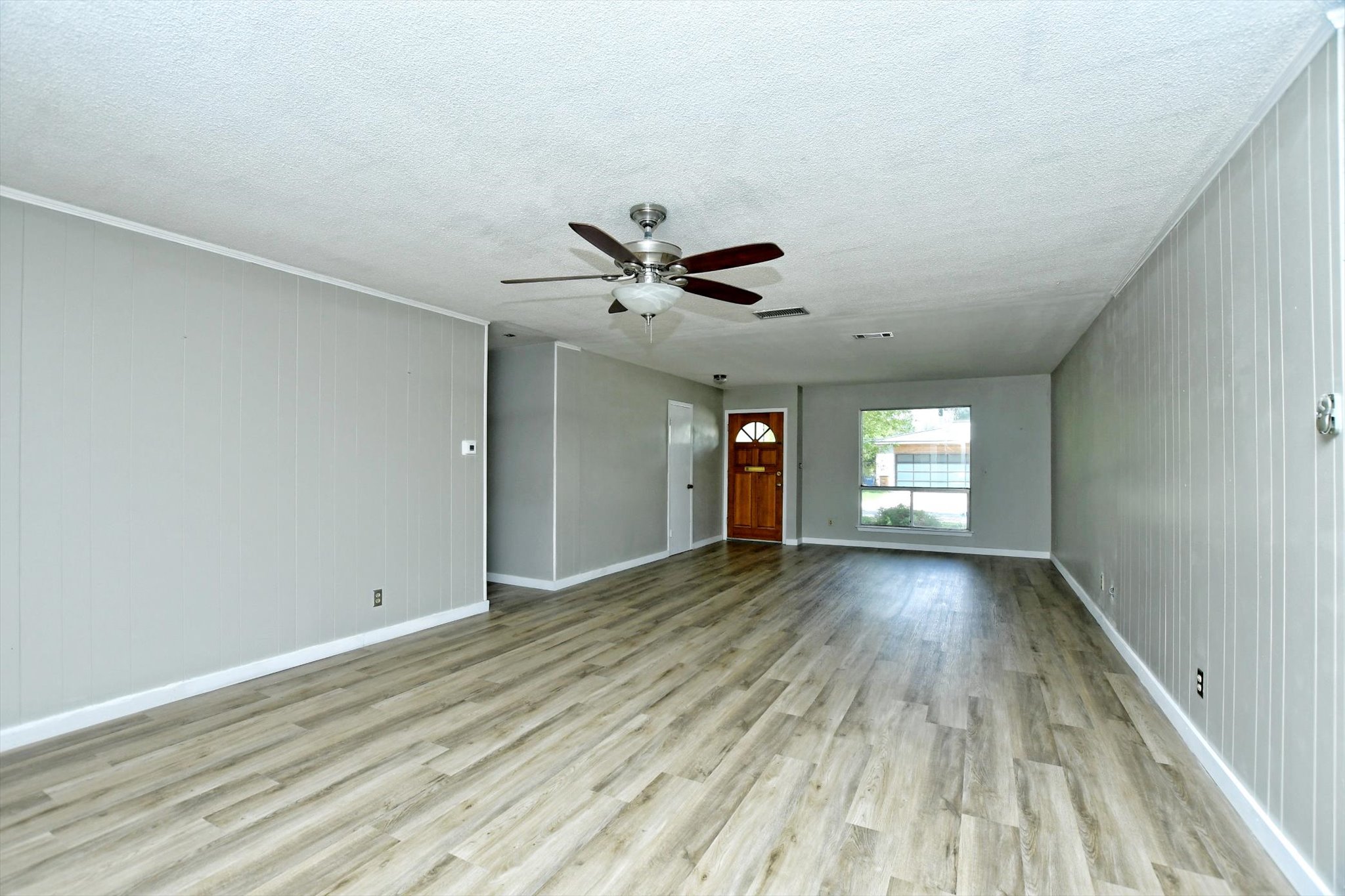 7509 Daugherty Street Austin, TX 78757 - Photo 4 of 24 a view of a livingroom with wooden floor and a ceiling fan