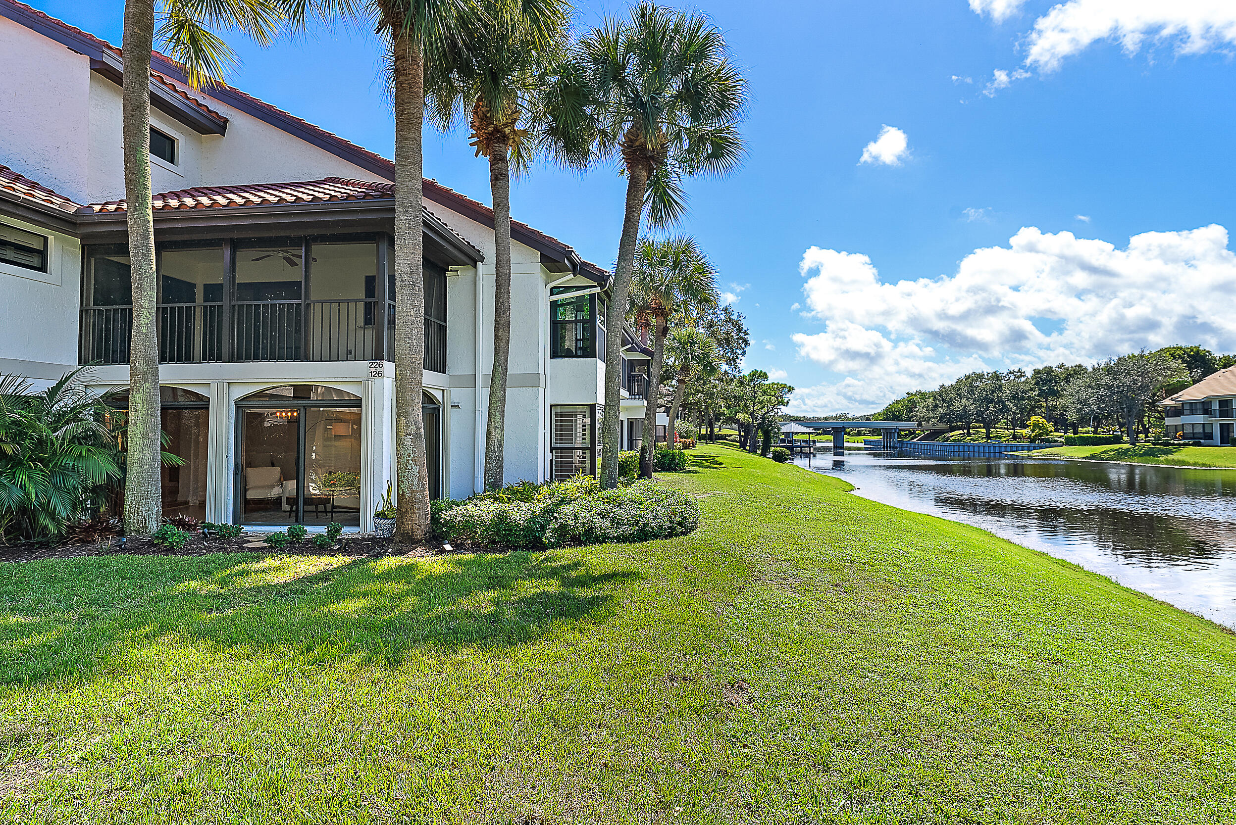 16647 Traders Crossing North, Unit 126 Jupiter, FL 33477 - Photo 1 of 45 a front view of a house with garden and lake view