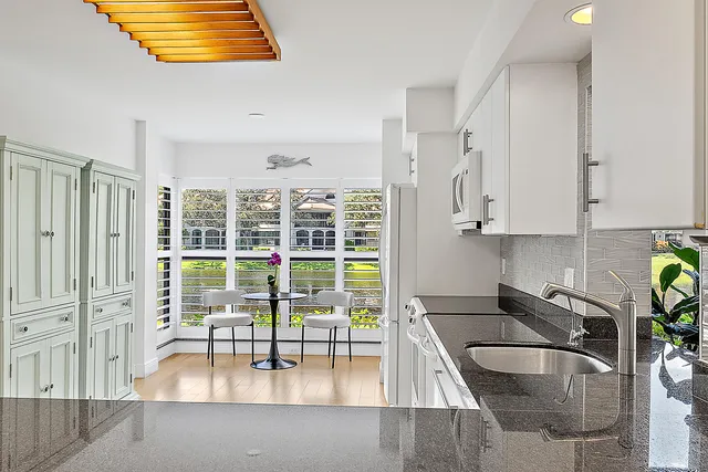a kitchen with granite countertop a sink a stove and cabinets