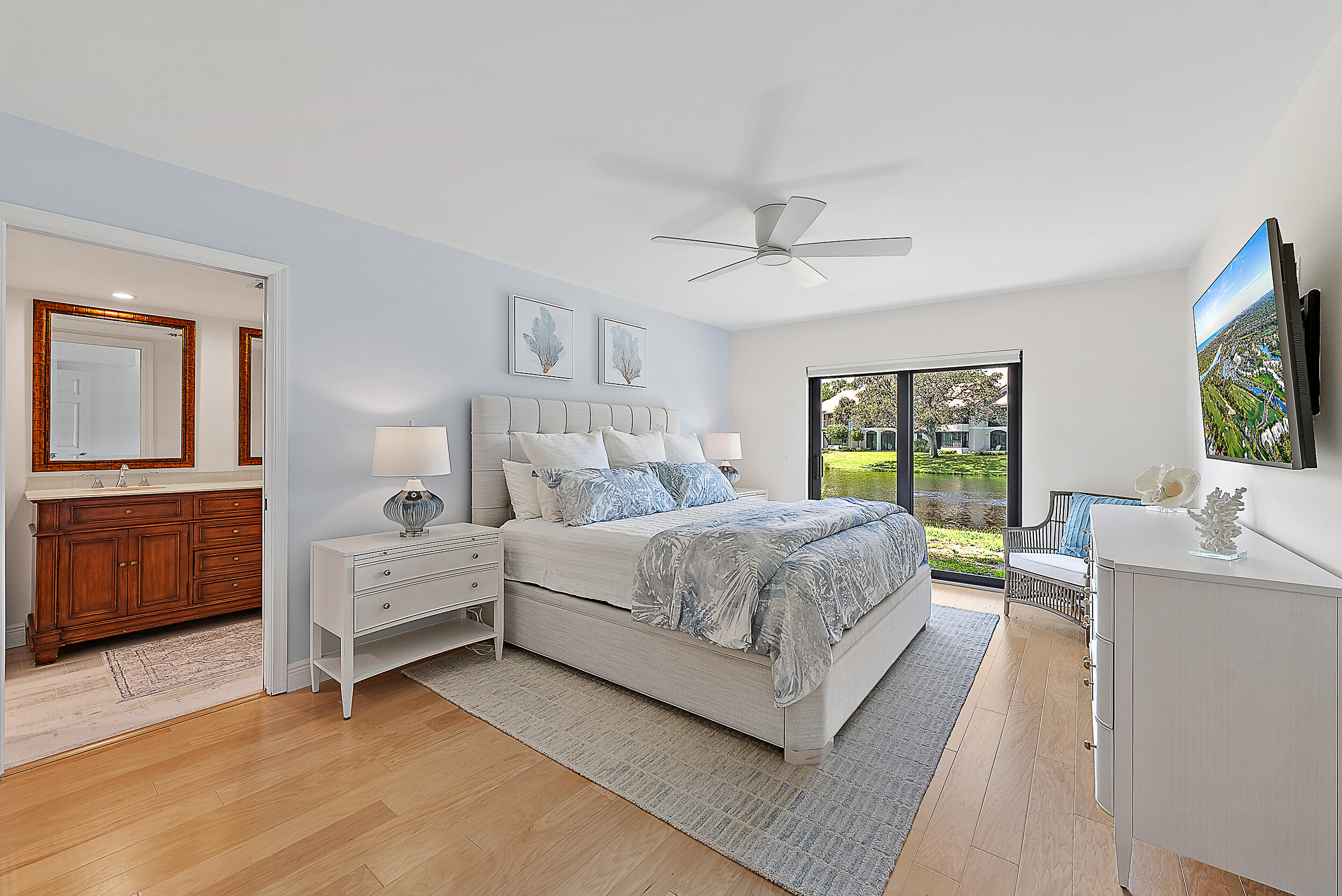 16647 Traders Crossing North, Unit 126 Jupiter, FL 33477 - Photo 17 of 45 a bedroom with a bed and a flat tv screen on dresser