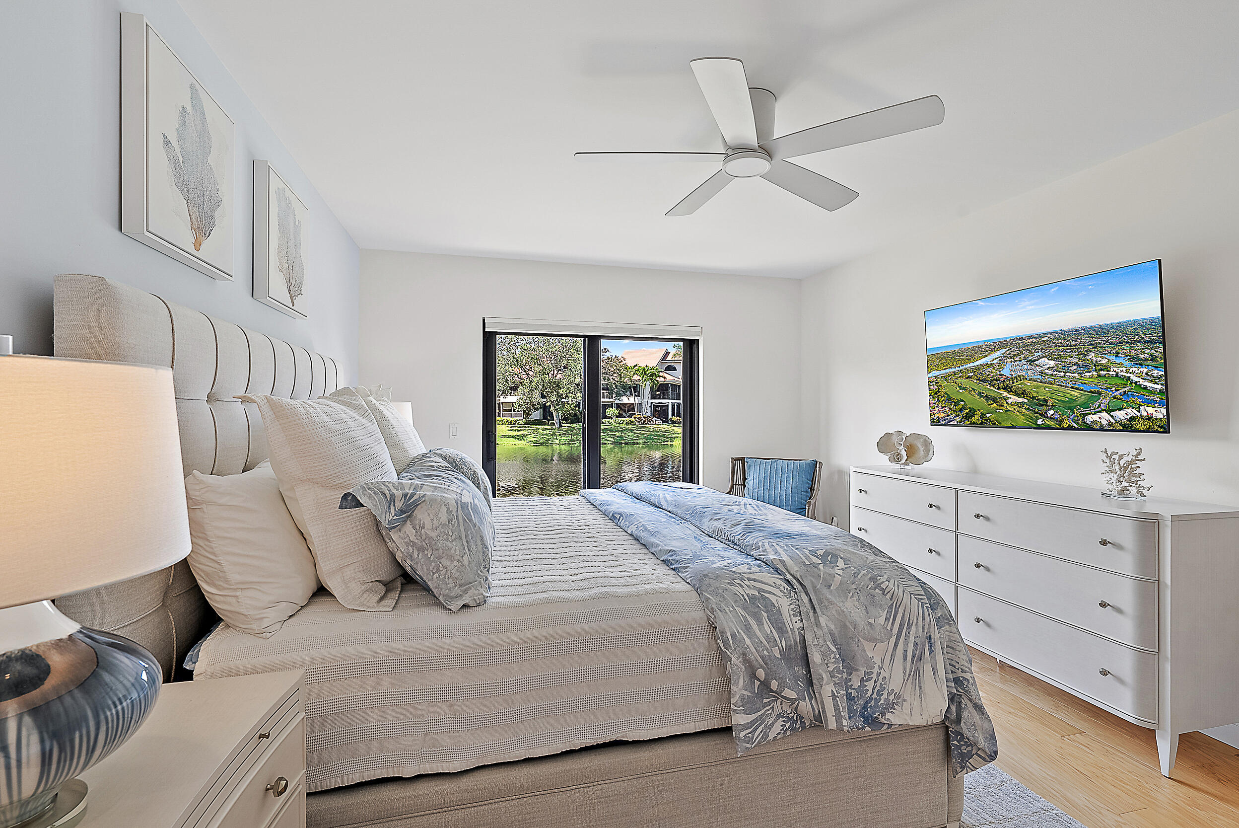 16647 Traders Crossing North, Unit 126 Jupiter, FL 33477 - Photo 18 of 45 a bedroom with a large bed and a flat tv screen on dresser