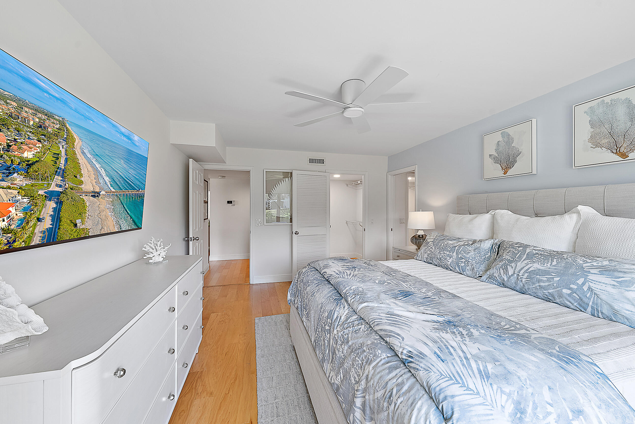 16647 Traders Crossing North, Unit 126 Jupiter, FL 33477 - Photo 20 of 45 a spacious bedroom with a large bed a flat tv screen and a dresser