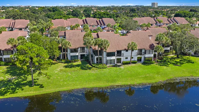 an aerial view of residential houses with outdoor space and lake view