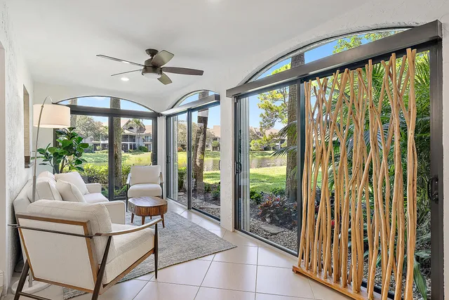 a living room with furniture and a floor to ceiling window