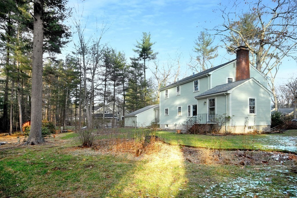 48 Wilson Road Concord, MA 01742 - Photo 37 of 41 a view of a white house with a large pool lawn chairs and plants